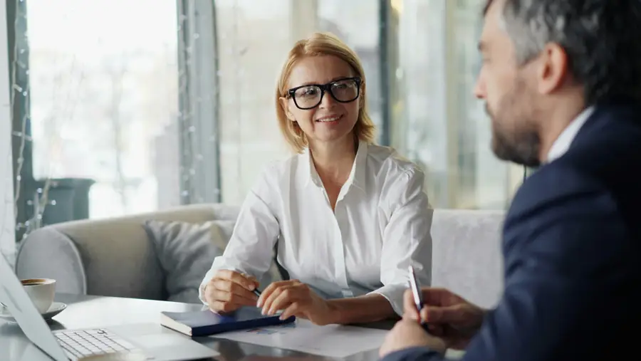 Una asesora conversa con un cliente en una sala de juntas