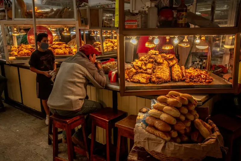Cliente frente al mostrador de una fonda con vitrinas de comida