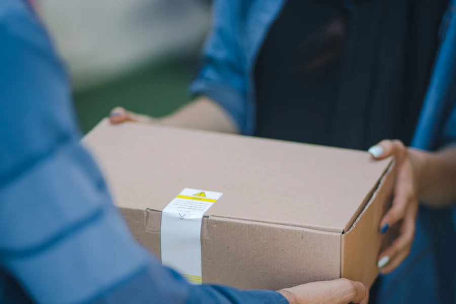 Dos personas se entregan una caja de envío