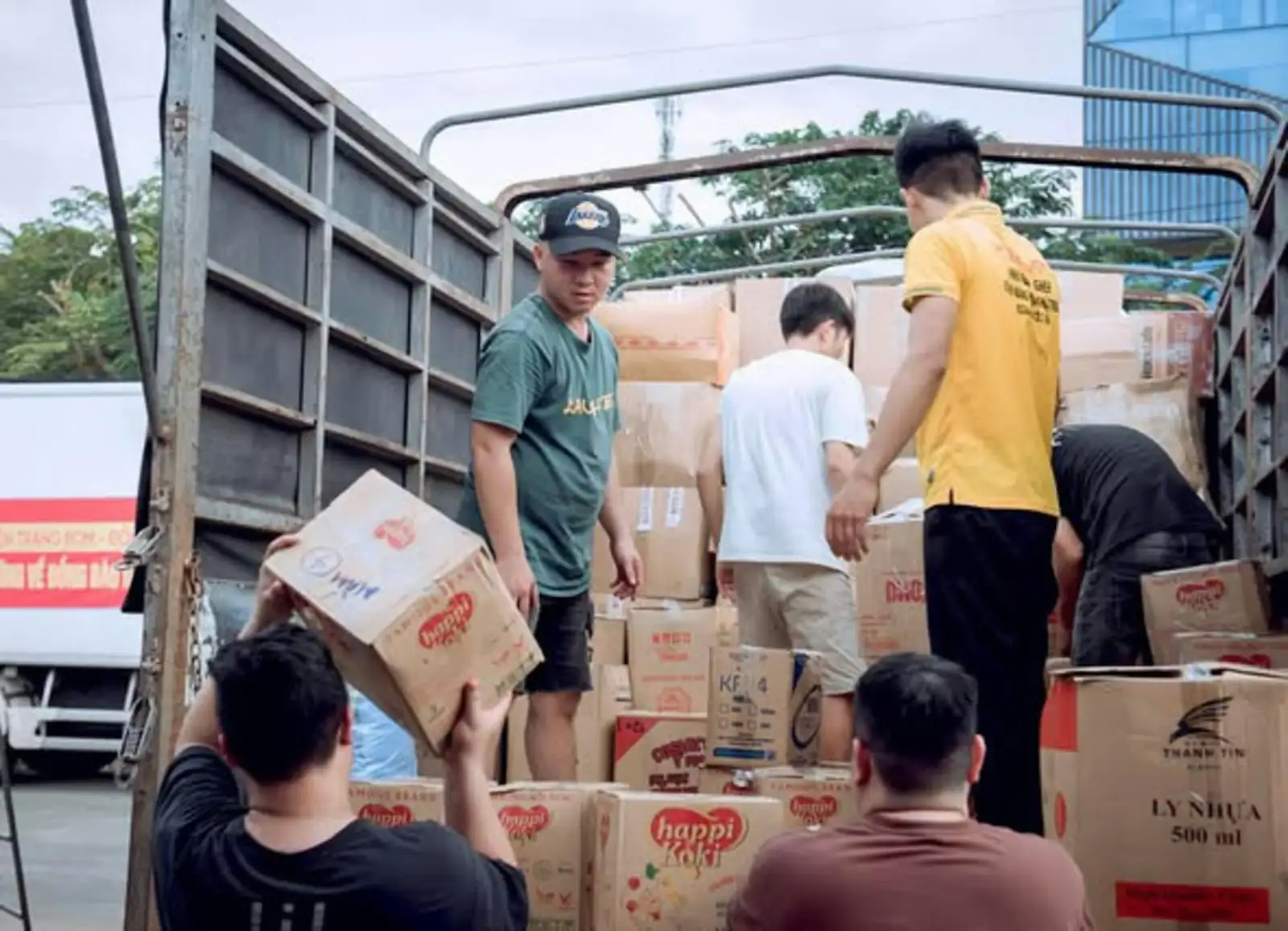 Un grupo de trabajadores carga cajas de mercancía en la caja de un camión